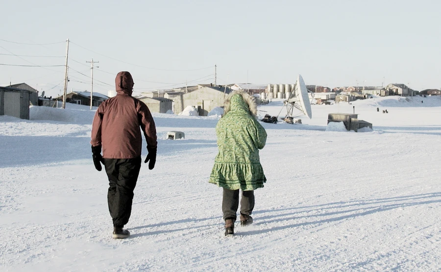 Alaska Natives walking in snow conditions.